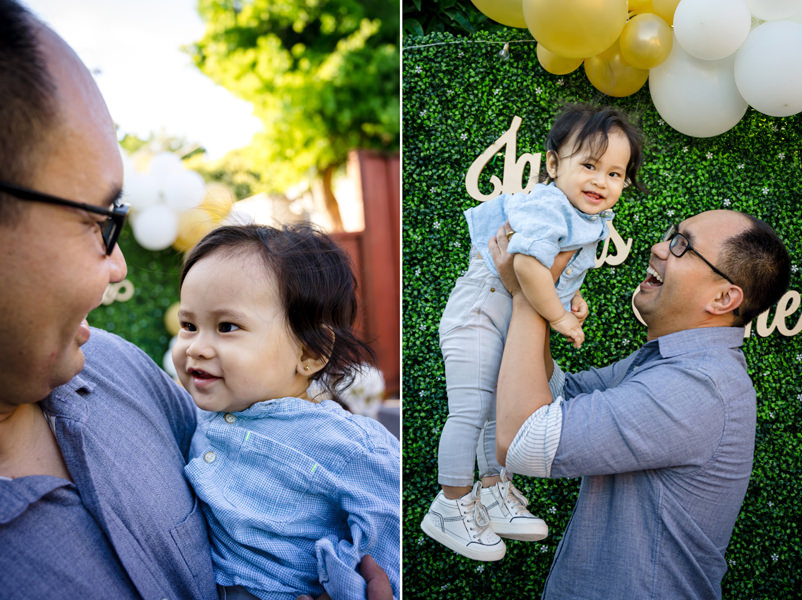A toddler smiles at his father at his 1st Birthday Party Celebration.
