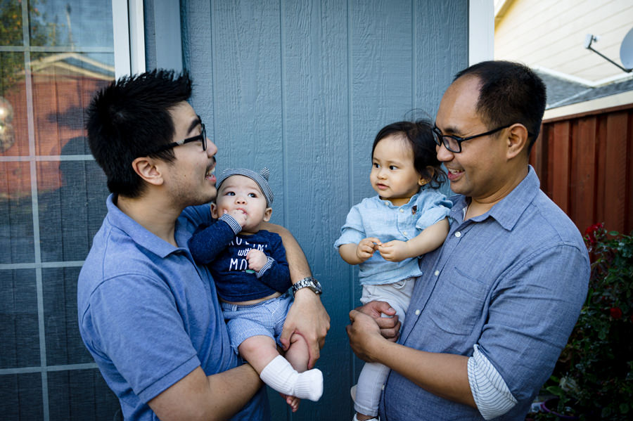 2 fathers having a great conversation while holding their babies.