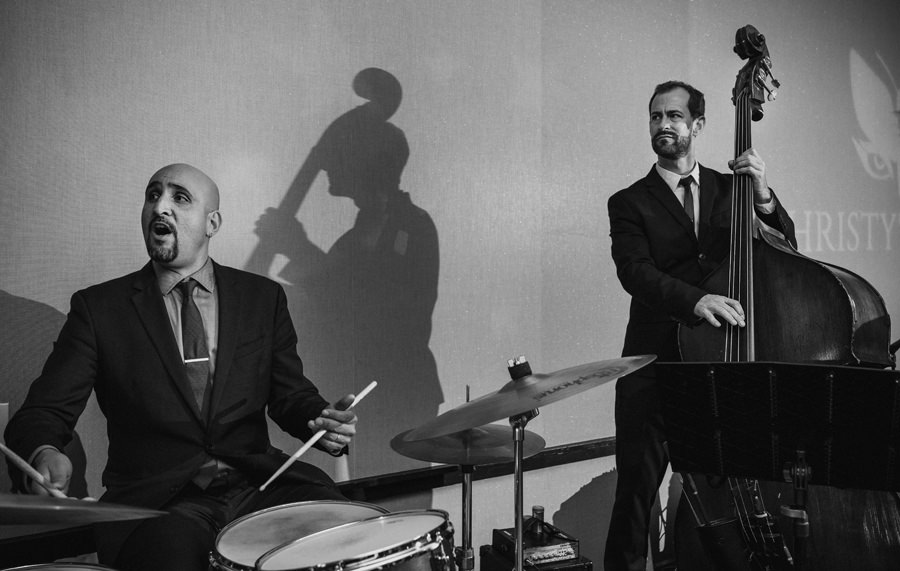 A black and white picture of a Jazz drummer and bassist at a party.