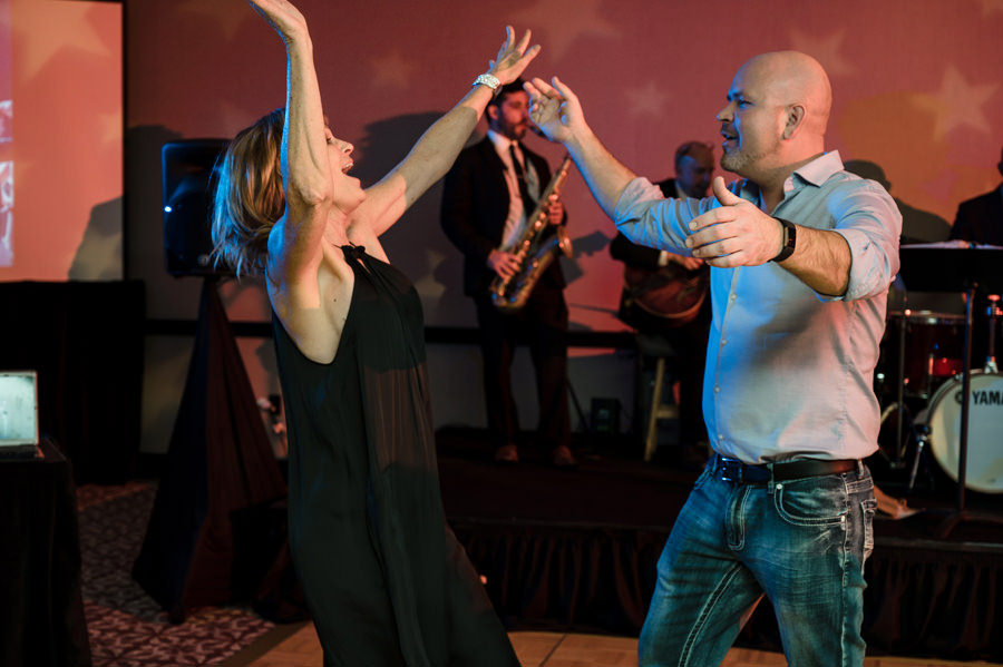 A candid image of a couple dancing at a party.