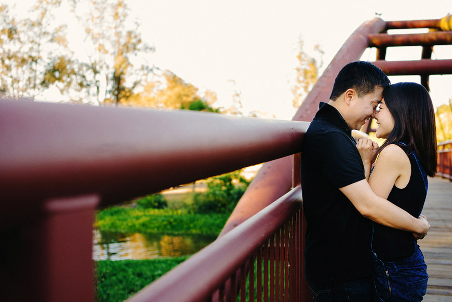 A man hugs his fiance on the red bridge