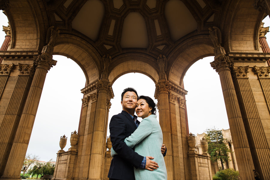 An engaged couple embraced under the dome of Palace of Fine Art in SF