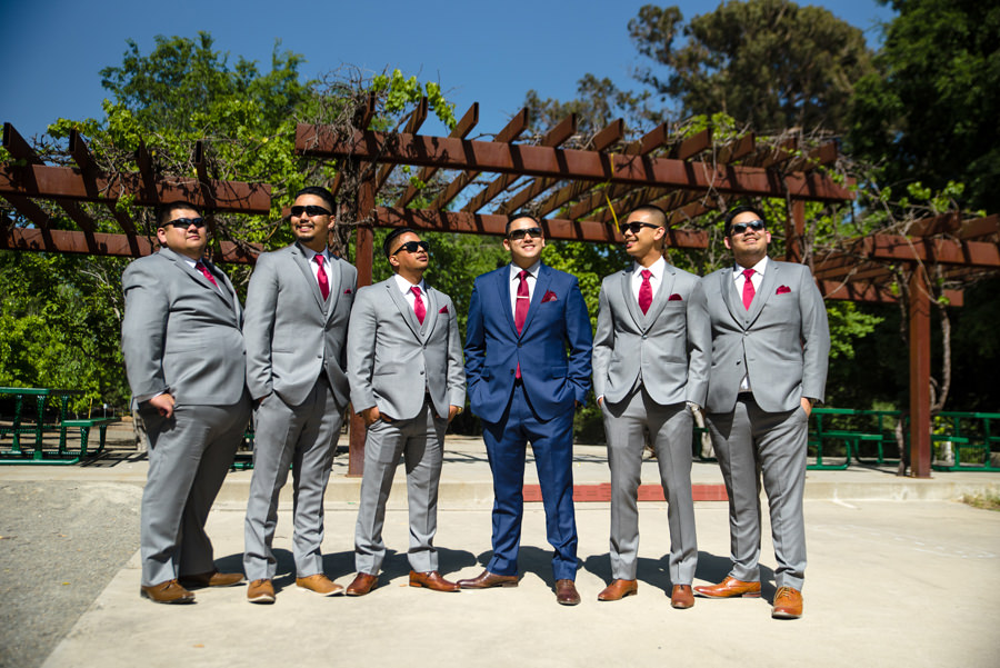 A groom with his groomsmen posed wearing their sunglasses