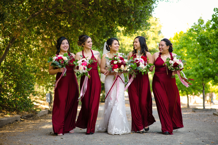 A gorgeous image of the bride and her bridesmaids walking on the park prior to her Wedding at Casa Bella in Sunol, CA.