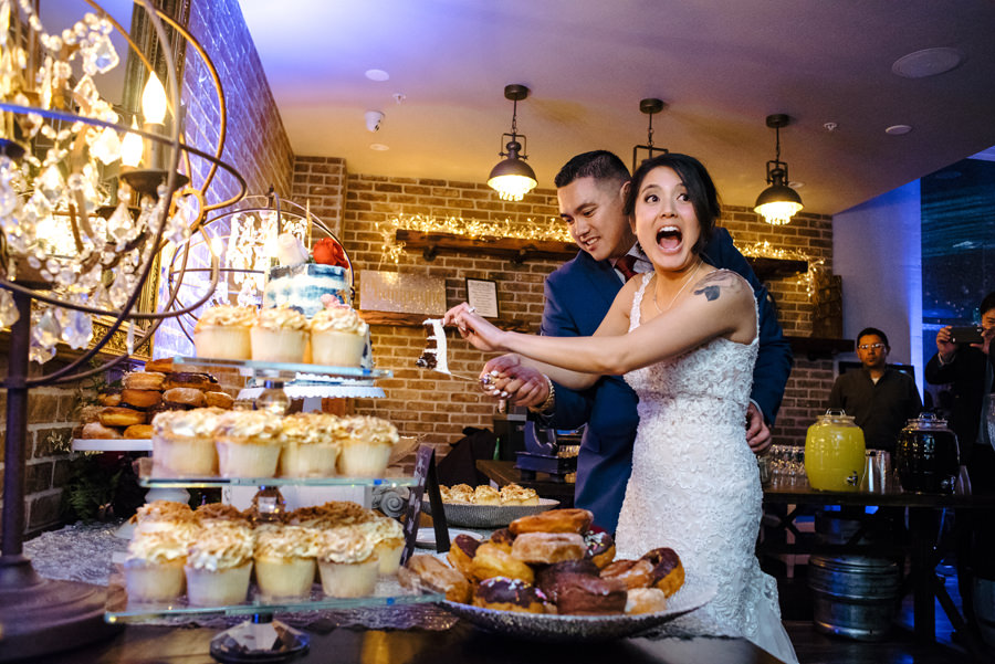 A newlywed cutting their wedding cake with excitement