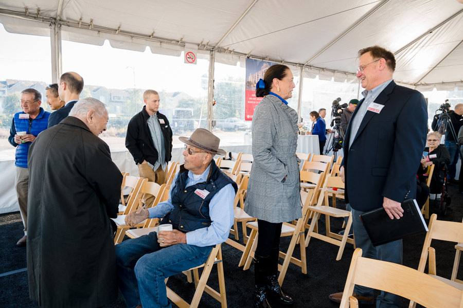 A candid photo of guests at a ground breaking ceremony mingles.