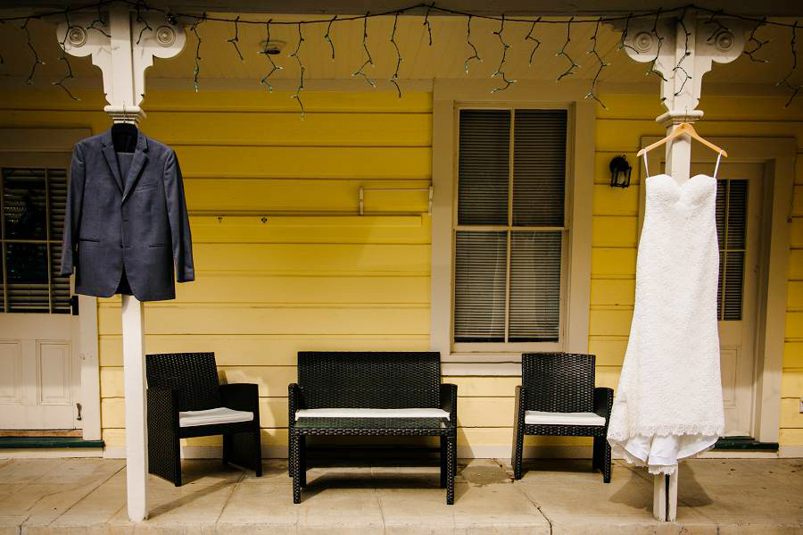 A picture of hanging Groom's suit and Bride's gown in front of the guest house where they are getting ready