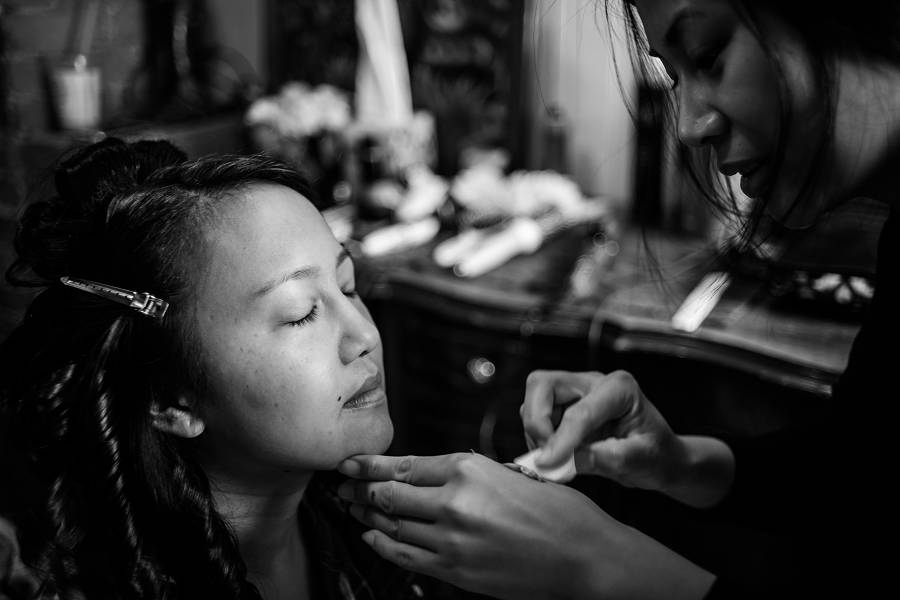 Photo of a bride getting her make up done by her friend