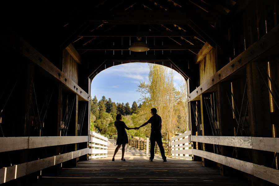 A silhouette image of a couple at the end of a bridge tunnel during their Engagement session at Roaring Camp
