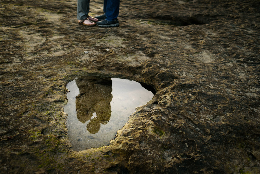 A cool photograph of a reflection on the water of a couple kissing