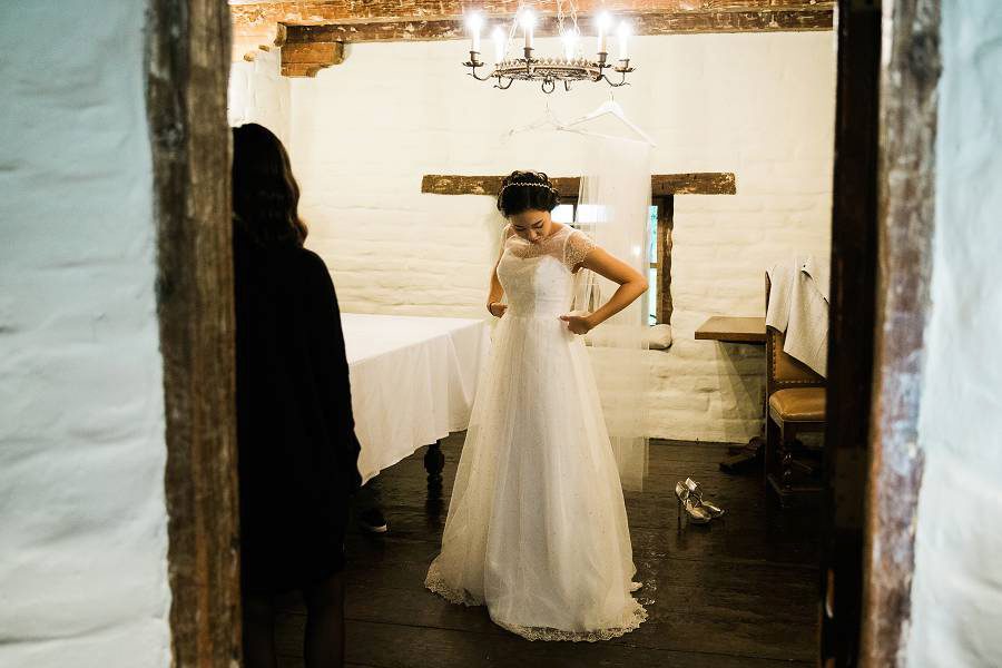 A bride getting ready while her sister looks on