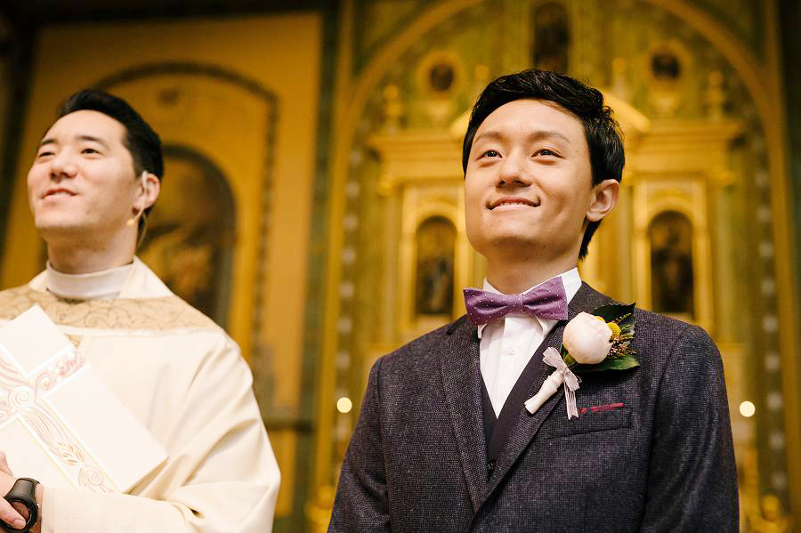 Groom and priest anxiously wait for the bride to walk in with her father at Santa Clara University Mission Church