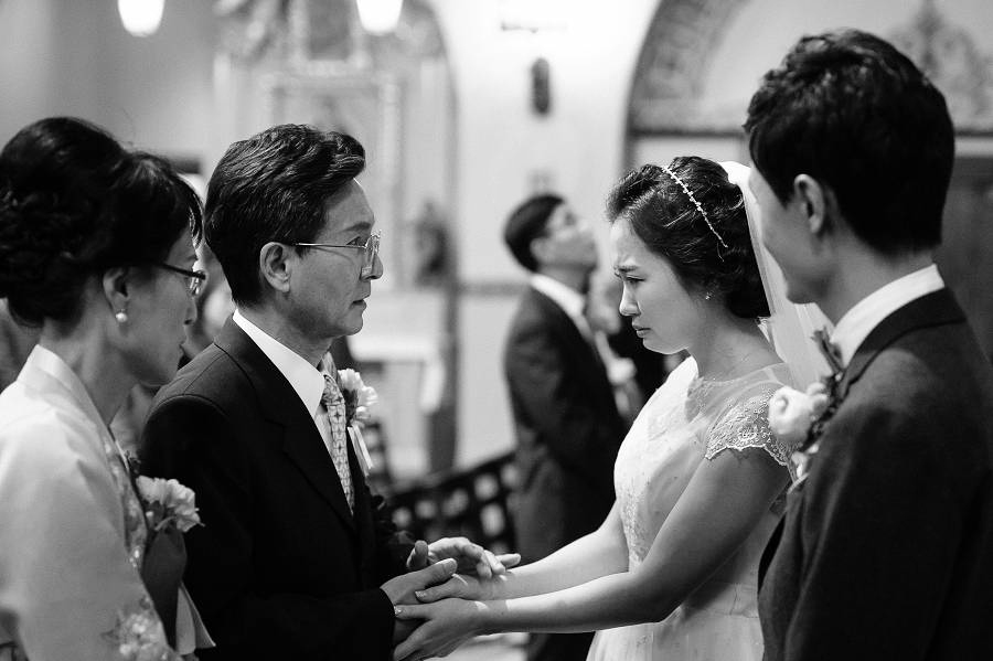Bride getting emotional while being welcomed by the groom's parents
