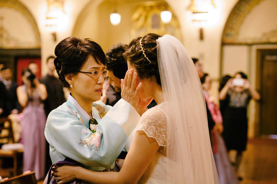 Groom's mom hold the face of the emotional bride