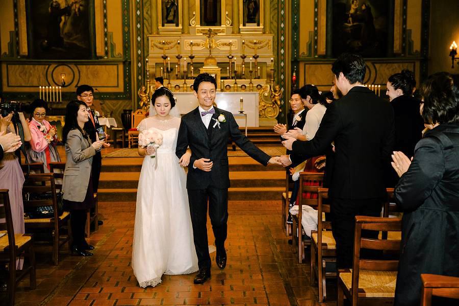 A friend giving a high five to the groom while walks out the aisle with his wife