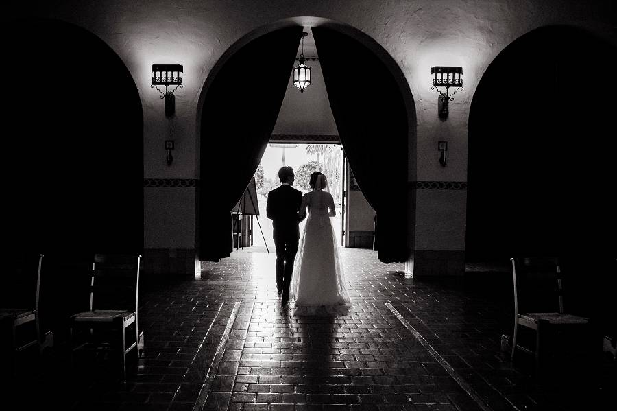 A cool silhouetted image of a newly wed as they walks out of the Santa Clara University Mission Church