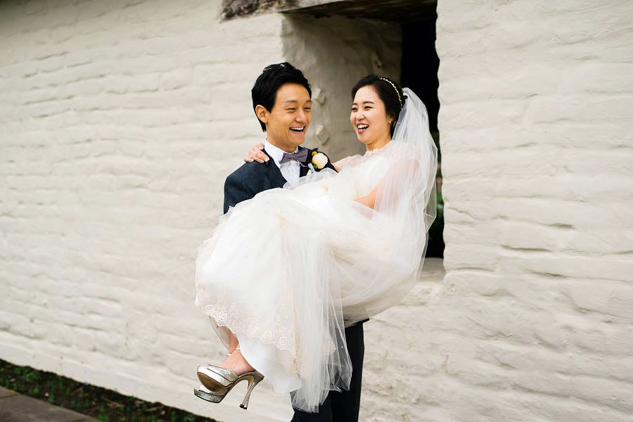 A laughing bride being carried away by her husband