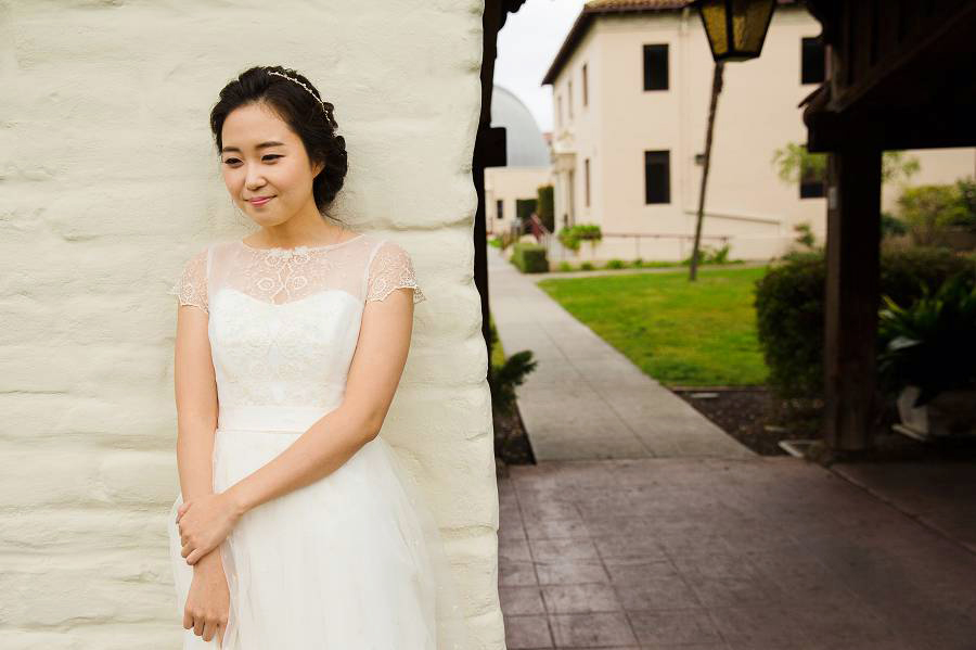 a beautiful bride leaning on the mission wall before her Santa Clara University Mission Church Wedding