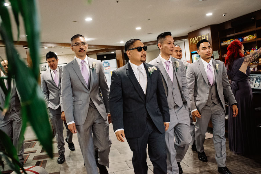 Groom and his groomsmen walking to their limo