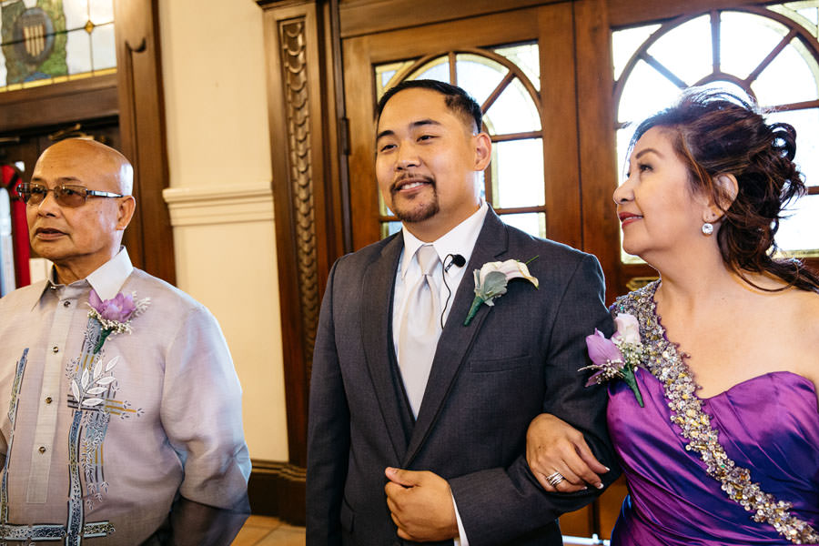 Mom looks at her son's face before walking on the aisle