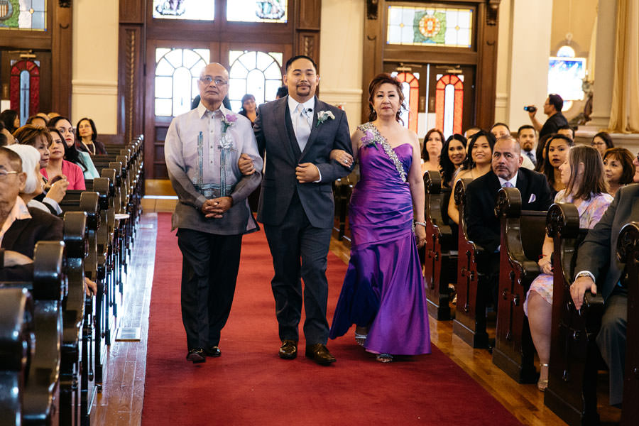 Father and mother walks their son on the aisle