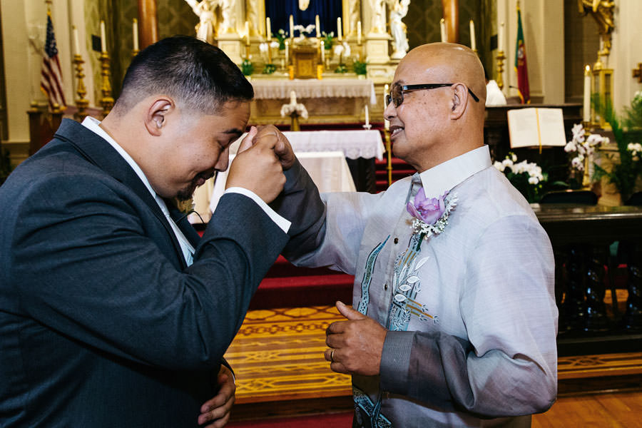Groom receives blessing from his dad on the altar