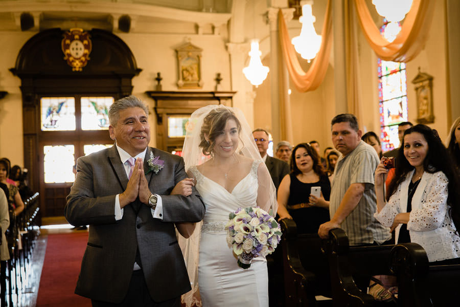A happy Father walks her daughter on the aisle