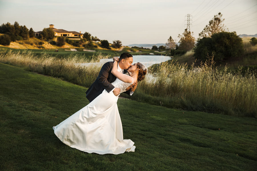 A beautiful photo of a groom kissing his bride with the lake in the background