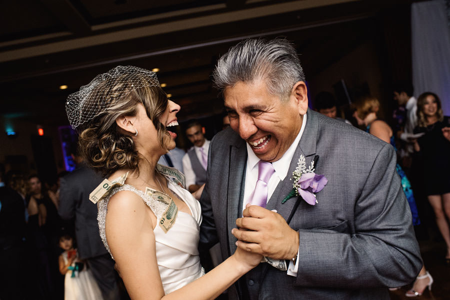 Father of bride dances with the bride and laughs incontrolably