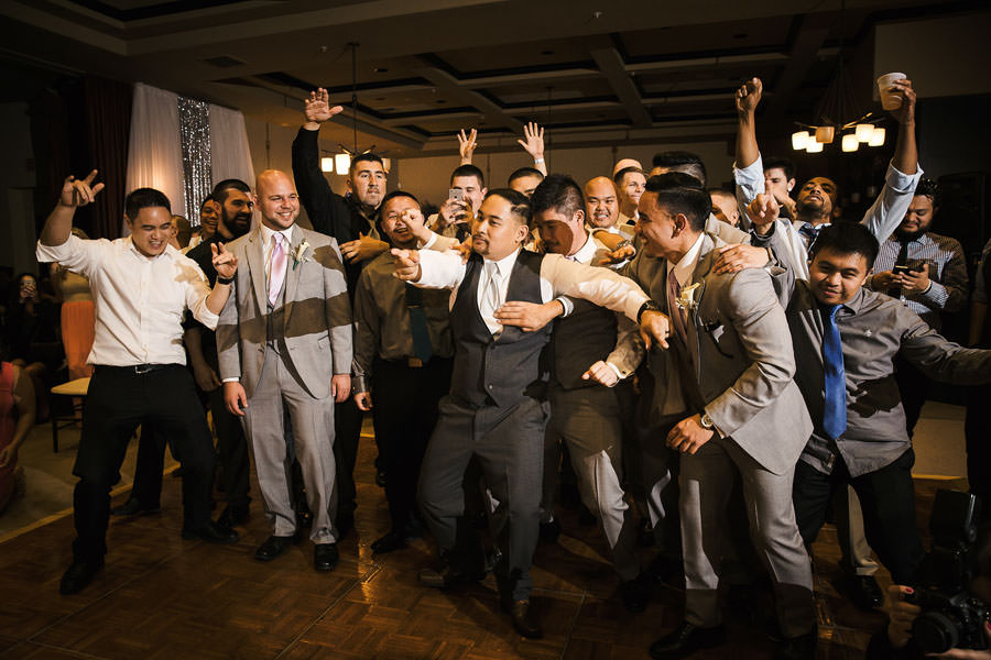 Rowdy Single guys hyping the groom to get his garter from the bride